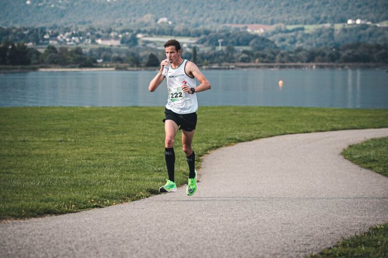 Hardloper drinkt water in de hitte tijdens de RunMotion Coach Marathon van Chambéry, aan het Lac du Bourget