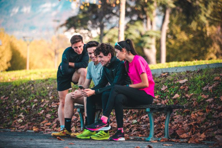 Hardlopers bekijken de RunMotion Coach-app op een telefoon