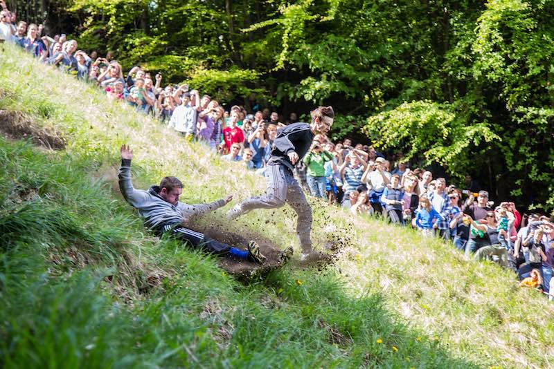 Hardlopers rollen achter een kaas aan tijdens Cooper's Hill, een bizarre hardloopwedstrijd ter wereld.