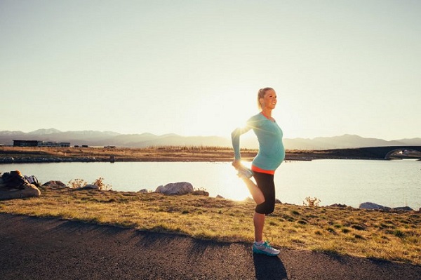 Zwangere vrouw hardloopt rustig buiten, veilig trainen met slimme hardlooptips tijdens zwangerschap.