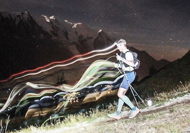 Trailrunner loopt ’s nachts veilig met hoofdlamp op donker bospad en sterke looptechniek.