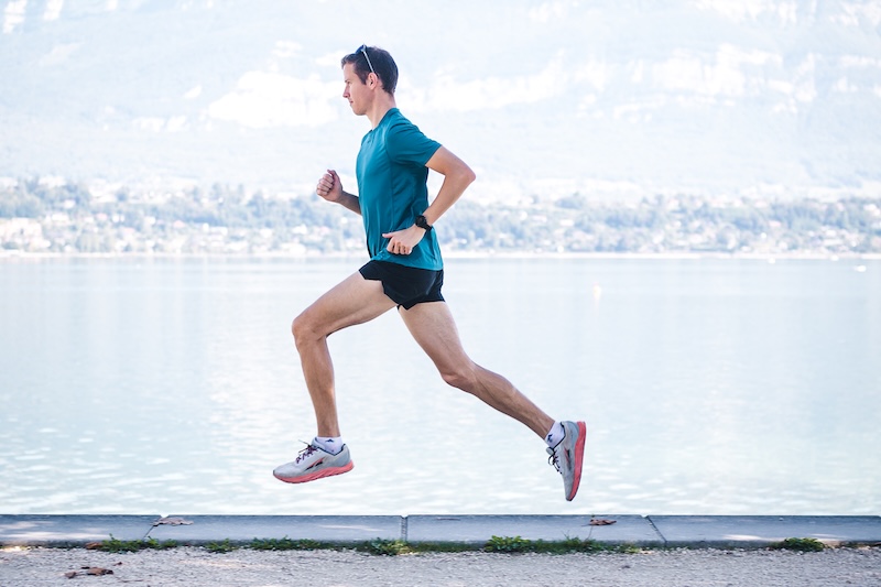 Loper draagt carbonschoenen tijdens een 10 km wedstrijd op weg naar een persoonlijk record.