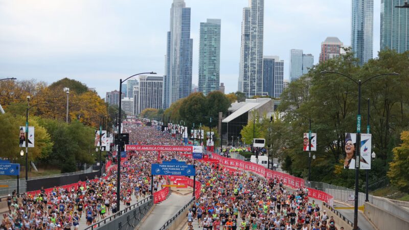 Lopers tijdens de Marathon van Chicago met de skyline op de achtergrond, inclusief parcours- en inschrijvingstips voor 2026.